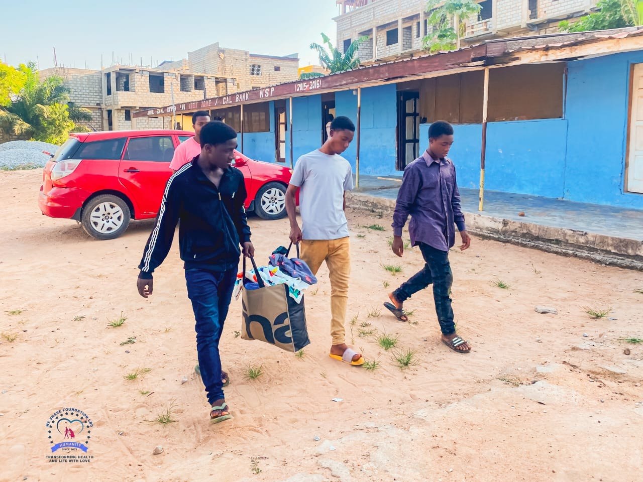 Volunteers carrying donated items to a community visit
